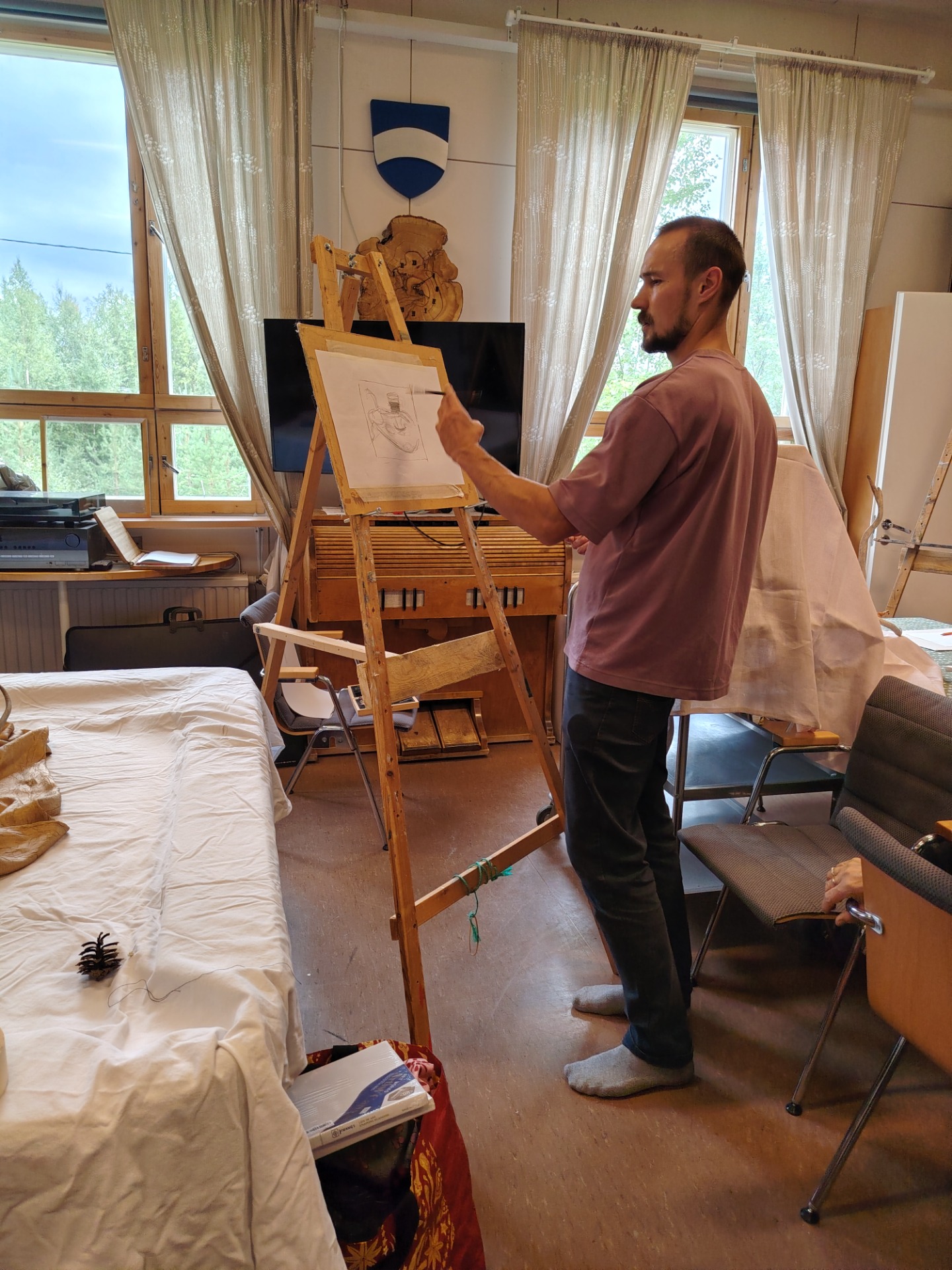 Taiteilija Hannes Helki demonstroi asetelman luonnostelua